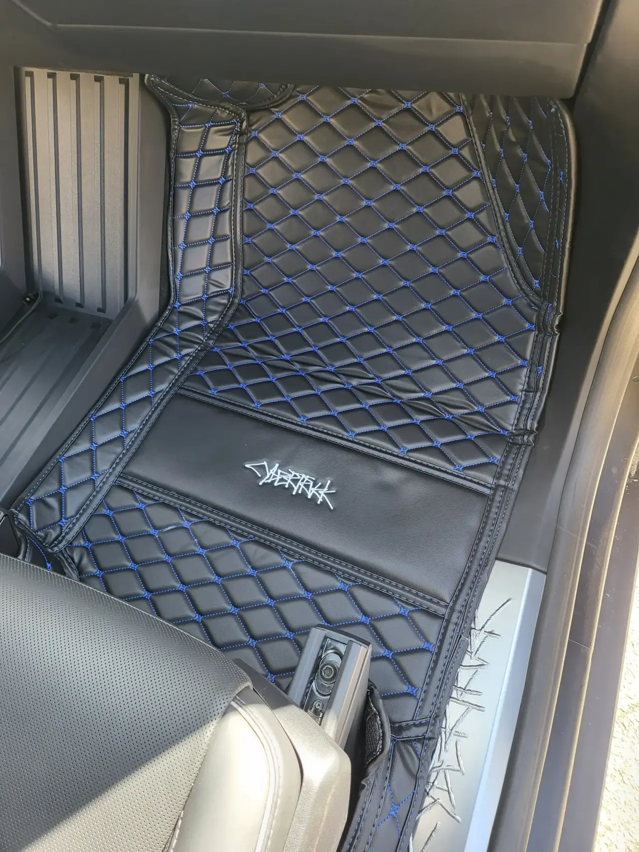 Custom leather floor mats installed in Tesla Cybertruck passenger's side